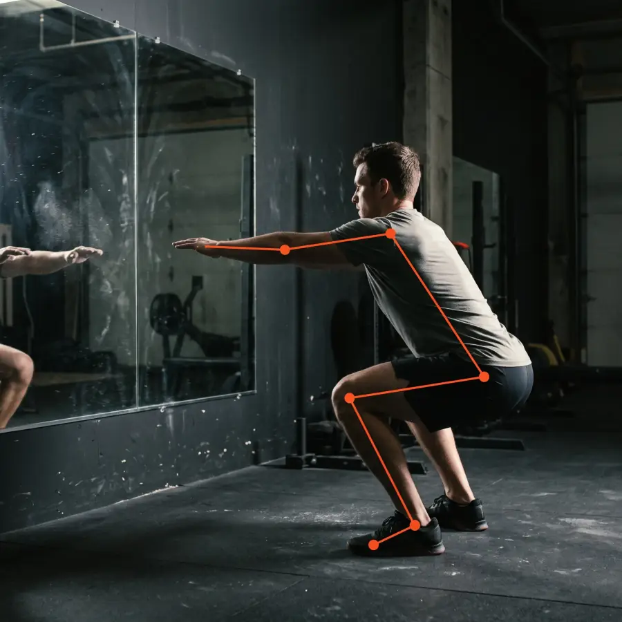 Un athlète fait un squat devant un miroir, avec des lignes orange sur ses articulations comme une analyse de mouvement